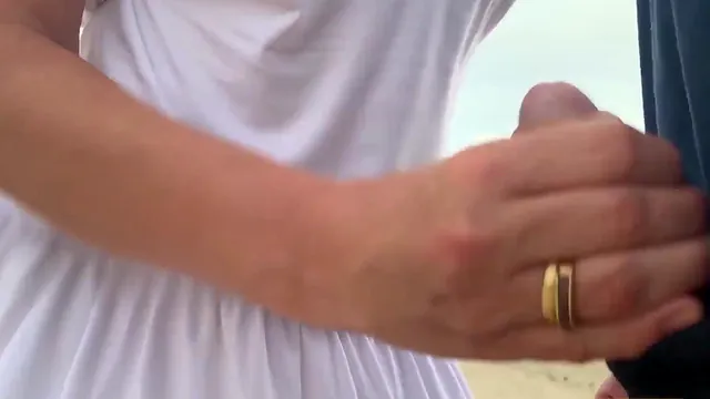 Jane R gives a handjob outdoors and an orgasm follows in public