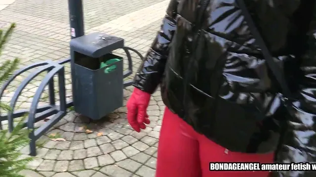 Bondageangel walks through town in a shiny hooded jacket and leather gear