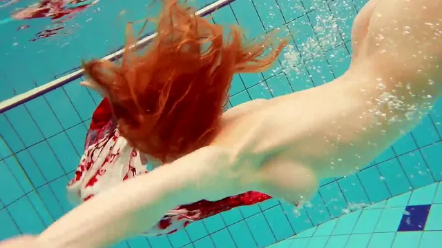 Hairy redhead Marketa poses naked beside the swimming pool