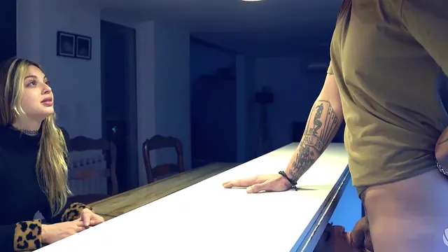 A woman slips under the kitchen table to suck off a friend's husband